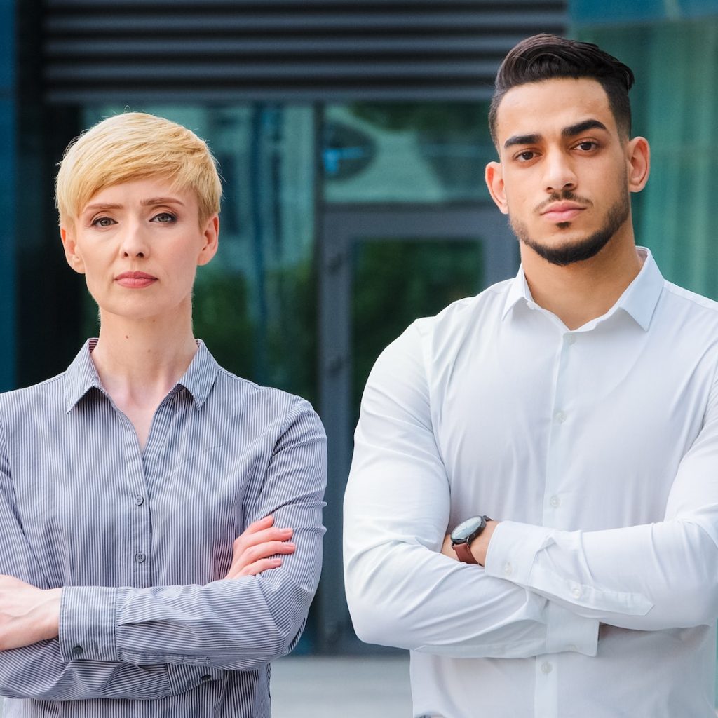 Multiracial couple of business colleagues serious co-workers caucasian mature woman with short hair