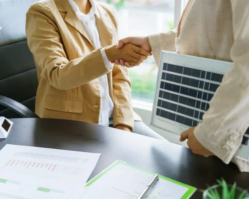 Handshake and business with solar panels green energy Business people working